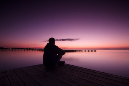 Man looking out over the water, reflecting on his life.